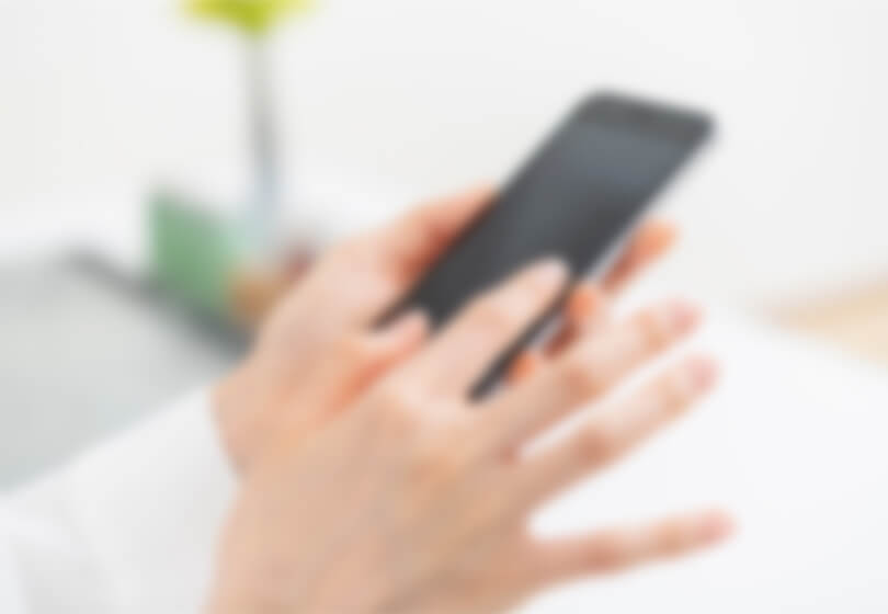 スマートフォンでWEB予約を行う女性のイメージ