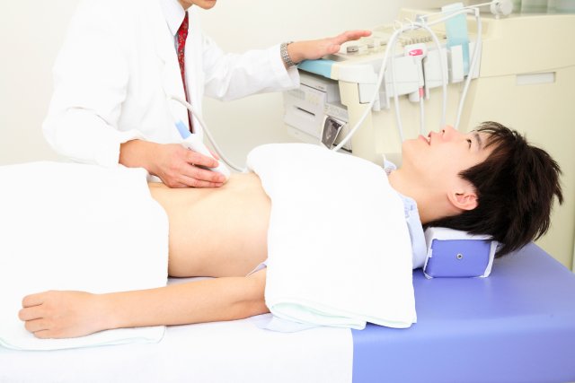 エコーで腹部を検査する男性患者